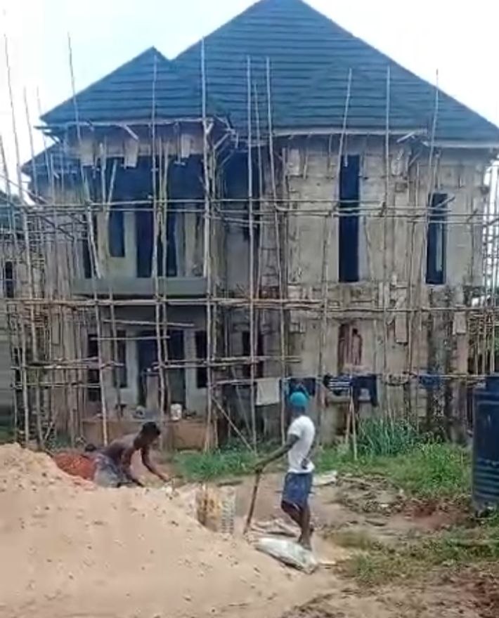N-SOL Construction project management at the Presidential Building in Agulu, Anambra State, showing the two-storey residential carcass under scaffolding with roof shingles installed.